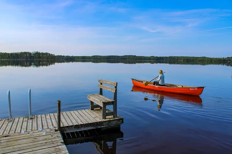Canoeing by a cottage pier in Finnish Lakeland
