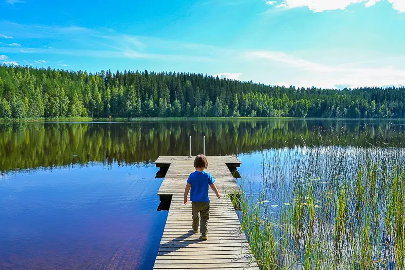 Little boy on a pier at a lakeside cottage in Kuhmoinen