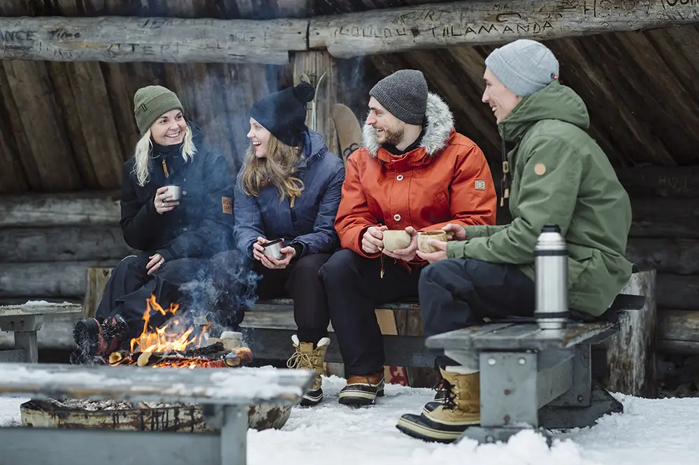 Friends around a campfire - Photo: Juho Kuva / Visit Finland